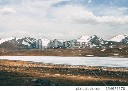 Frozen lake with snowy mountains in the background. Winter landscape 134972378