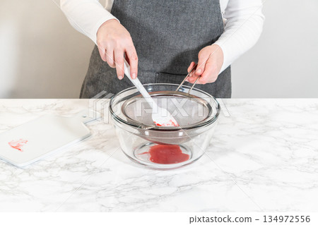 A beautiful collection of decorated Easter Cookie Sandwiches filled with raspberry buttercream frosting in bright yellow, green, and pink. Great for spring content and festive visuals. 134972556