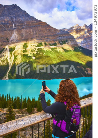 Tourist Hiker Taking Photo of Turquoise Lake and Mountains in Banff National Park Tourist Hiker Taking Photo of Turquoise Lake and Mountains in Banff National Park 134972972