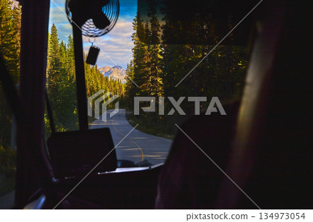 Bus Interior Winding Road and Mountain Forest Landscape at Sunset 134973054