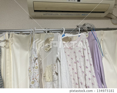 Laundry being hung to dry indoors in the space under the air conditioner 134973181