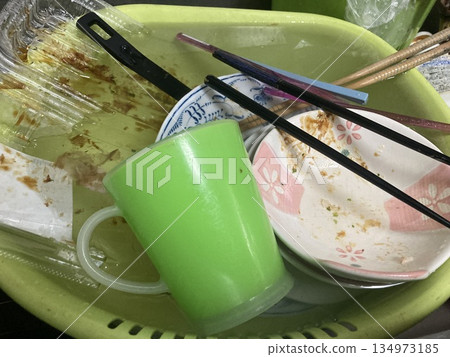 飯後髒盤子和杯子堆在洗衣盆裡。 134973185