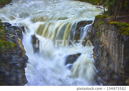 Sunwapta Falls Rushing Water Over Rocky Cliffs and Lush Forest in Jasper Canada 134973582