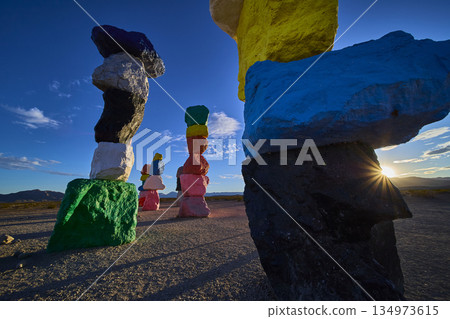 Seven Magic Mountains Colorful Rock Cairn Stacks at Sunset with Sunburst Nevada Seven Magic Mountains Colorful Rock Cairn Stacks at Sunset with Sunburst Nevada 134973615