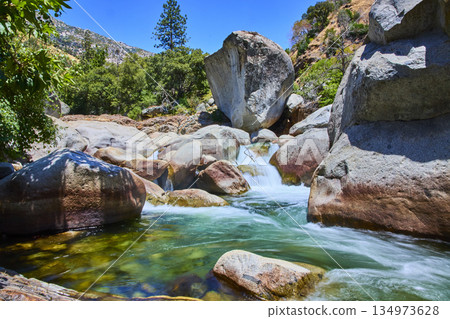 Middle Fork Kaweah River Flowing Through Granite Boulders and Lush Forest Scenery 134973628