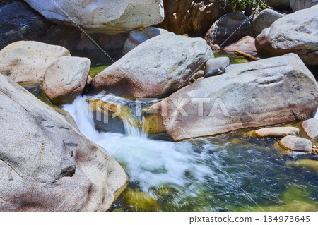 Rushing River Water and Smooth Granite Boulders in Sunlit Nature Scene Rushing River Water and Smooth Granite Boulders in Sunlit Nature Scene 134973645