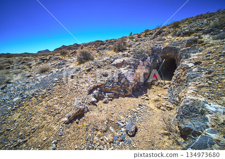 Abandoned Mine Entrance Desert Landscape and Rocky Terrain in Harsh Sunlight Abandoned Mine Entrance Desert Landscape and Rocky Terrain in Harsh Sunlight 134973680
