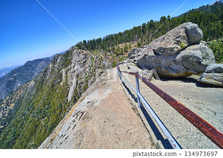 Moro Rock Trail Granite Outcrop and Forested Mountains Under Bright Blue Sky Moro Rock Trail Granite Outcrop and Forested Mountains Under Bright Blue Sky 134973697
