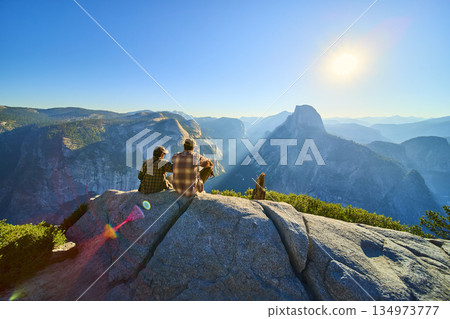 Couple Enjoying Sunrise at Glacier Point Overlooking Half Dome in Yosemite National Park Couple Enjoying Sunrise at Glacier Point Overlooking Half Dome in Yosemite National Park 134973777