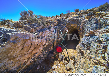 Abandoned Mine Entrance with Warning Sign and Desert Landscape in Nevada 134973781