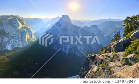 Panorama of Half Dome from Glacier Point with Sunbeam and Rugged Yosemite Cliffs Panorama of Half Dome from Glacier Point with Sunbeam and Rugged Yosemite Cliffs 134973847