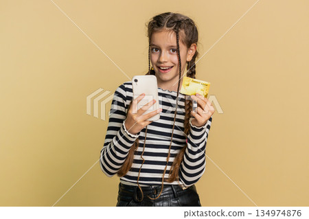 Child girl use credit bank card smartphone while transferring spend money purchases online shopping 134974876
