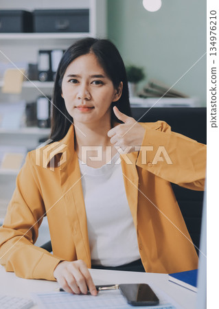 Business woman using calculator for do math finance on wooden desk in office and business working background, tax, accounting, statistics and analytic research concept. 134976210
