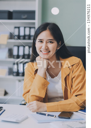 Business woman using calculator for do math finance on wooden desk in office and business working background, tax, accounting, statistics and analytic research concept. Business woman using calculator for do math finance on wooden desk in office and business working background, tax, accounting, statistics and analytic research concept. 134976211