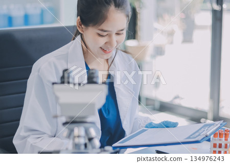Portrait, science and happy woman on laptop in lab to research chemistry, test or innovation. Microscope, scientist and face of medical doctor in goggles for microbiology, healthcare or pharma study 134976243