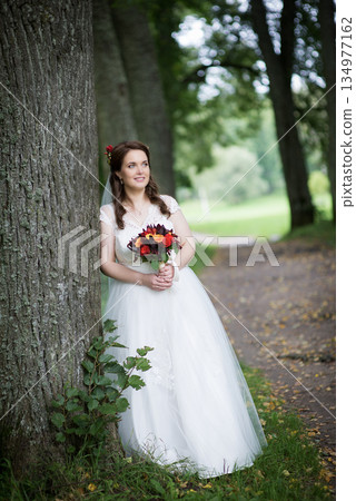 Young Bride Smiling Gently With Bouquet 134977162
