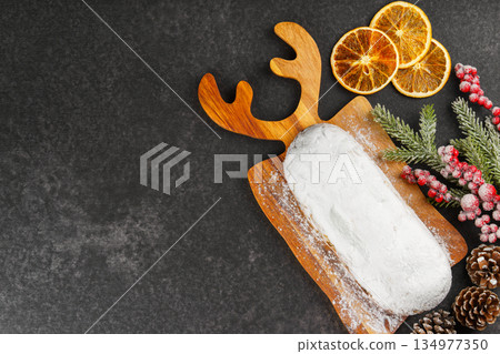 Traditional Christmas Stollen, sweet fruit loaf with sugar icing on wooden board and festive decor Traditional Christmas Stollen, sweet fruit loaf with sugar icing on wooden board and festive decor 134977350