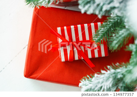 Red wrapped gift boxes, presents under festive Christmas tree with lights and holiday decorations Red wrapped gift boxes, presents under festive Christmas tree with lights and holiday decorations 134977357