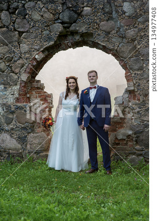 Young Wedding Couple Framed By Stone Arch Young Wedding Couple Framed By Stone Arch 134977408