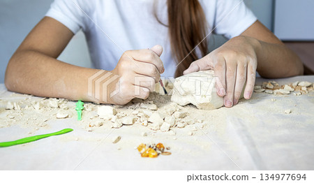 Young artist carves a stone sculpture at a table during a craft workshop Young artist carves a stone sculpture at a table during a craft workshop 134977694