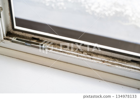 Dirty plastic window. Dust-covered plastic window frame and sill with dirt buildup and stains. Spring home cleaning concept Dirty plastic window. Dust-covered plastic window frame and sill with dirt buildup and stains. Spring home cleaning concept 134978133