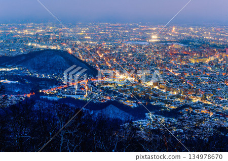 Night view of Sapporo cityscape in winter at twilight from Mt. Moiwa observation, the best city view point, Sapporo, Hokkaido, Japan Night view of Sapporo cityscape in winter at twilight from Mt. Moiwa observation, the best city view point, Sapporo, Hokkaido, Japan 134978670