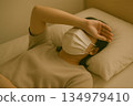 Indoor scene of a person lying in bed and feeling unwell 134979410