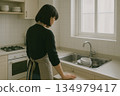 Rear view of a person suffering from poor health in the kitchen 134979417