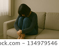Indoor image of a woman thinking deeply on the sofa 134979546
