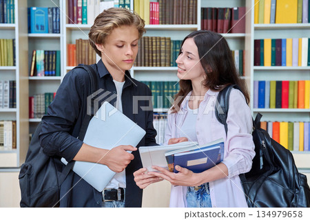 Portrait of two teenage students classmates boy and girl talking at school 134979658