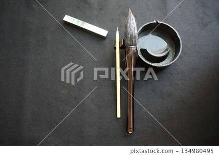 Calligraphy tools and copy space on a black background (overhead shot) 134980495