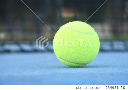 yellow tennis ball drop court with white border line on blue floor 134981458