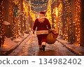 Santa Claus walks through a charming street decorated for Christmas 134982402