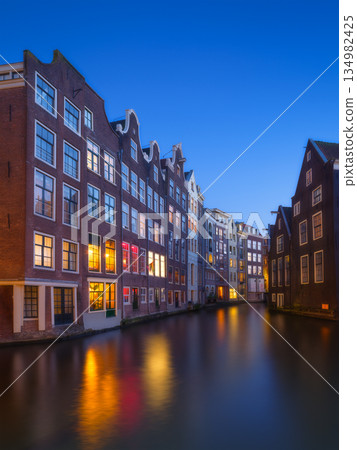 Beautiful Amsterdam canal at twilight with historic dutch architecture and city lights Beautiful Amsterdam canal at twilight with historic dutch architecture and city lights 134982425