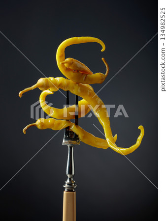 Canned yellow peppers on a black background. 134982525
