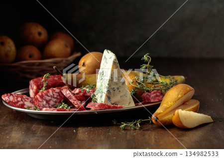 Dry-cured sausages, blue cheese, thyme and pears. Dry-cured sausages, blue cheese, thyme and pears. 134982533