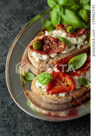 Ciabatta with sun dried tomatoes in olive oil, ricotta and basil. Ciabatta with sun dried tomatoes in olive oil, ricotta and basil. 134982542