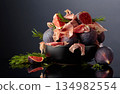Prosciutto with rosemary and fig fruit on a black reflective background. 134982554