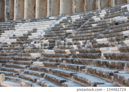 Part of the amphitheater with a stone staircase and a wall in the background. The wall has arches 134982729