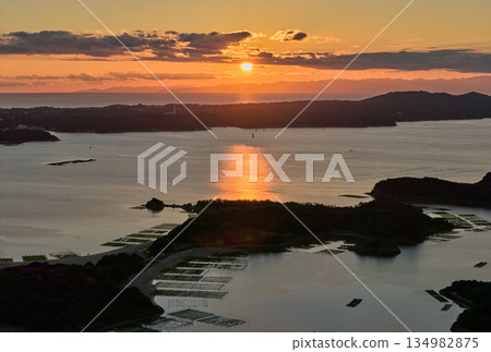 夕陽西下,阿戈灣的島嶼和寧靜的海面在空中交相輝映。 夕陽西下,阿戈灣的島嶼和寧靜的海面在空中交相輝映。 134982875