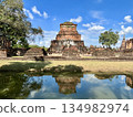 Wat Mahathat ruins and stone statues in Sukhothai Historical Park reflected in the water 134982974