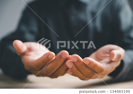 Close-up of open hands with fingers spread, held out towards the viewer. The hands are soft and pale with manicured nails. The background is out of focus. 134983199