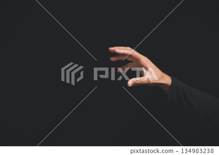 A hand reaches out from the darkness, fingers outstretched, creating a sense of mystery and suspense. . A hand reaches out from the darkness, fingers outstretched, creating a sense of mystery and suspense. . 134983238