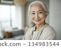 人工智慧生成的圖像：一位日本老年女性在客廳裡看著鏡頭的肖像 134983544