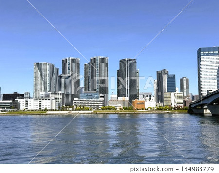 Kachidoki Bridge over the Sumida River and high-rise apartment buildings. Tokyo city seen from Toyosu Park. Spring. Kachidoki Bridge over the Sumida River and high-rise apartment buildings. Tokyo city seen from Toyosu Park. Spring. 134983779