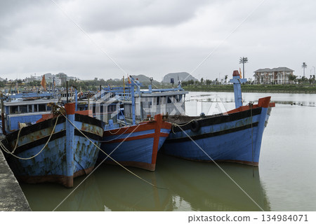 Traditional colorful Vietnamese fishing boats moored on a calm river in Da Nang, Vietnam. Traditional colorful Vietnamese fishing boats moored on a calm river in Da Nang, Vietnam. 134984071