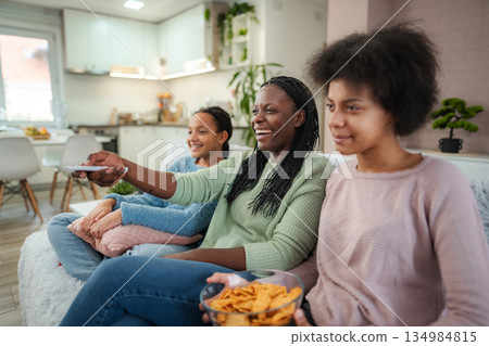 African American mother and daughters watching TV 134984815