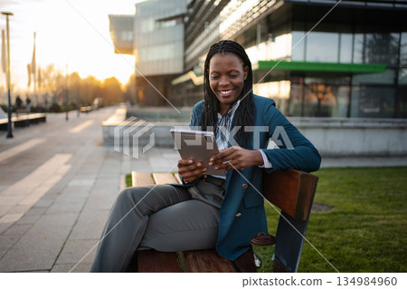 Businesswoman using digital tablet computing on city break 134984960