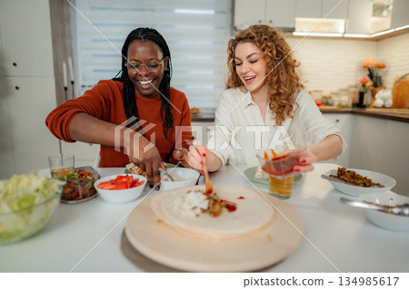 Diverse women friends preparing tasty tortillas for lunch 134985617