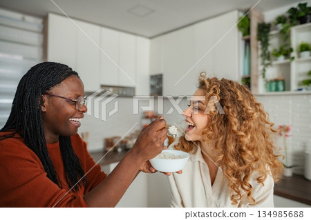 Diverse friends sharing breakfast and laughter in kitchen 134985688